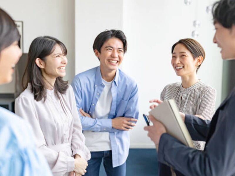 明るいオフィスで協力して仕事を進める3人のビジネスパーソンのイメージ